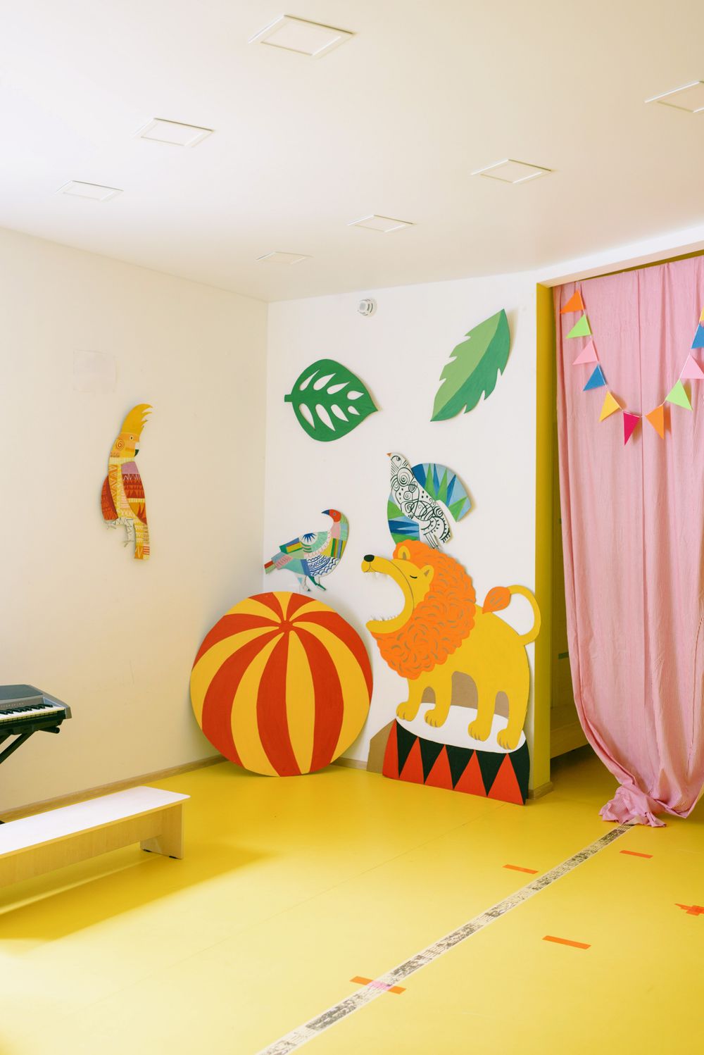 Tierfiguren und bunte Wandgestaltung in einem Kita-Spielbereich
