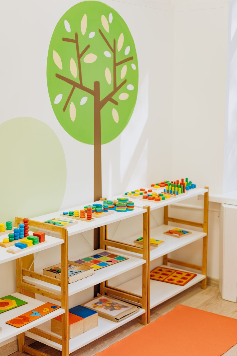 Lern- und Spielmaterial auf niedrigen Regalen einer Kita