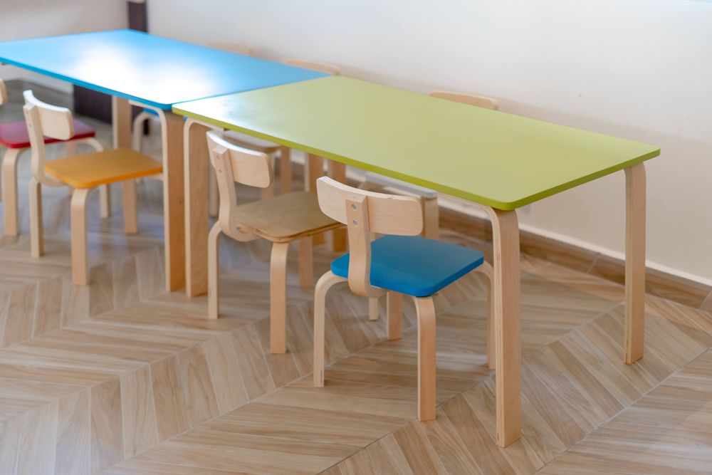 Bunte Kindertische und kleine Stühle in einem Gruppenraum