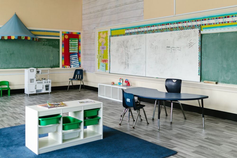 Kindergarten-Lernraum mit niedrigen Tischen und Tafeln